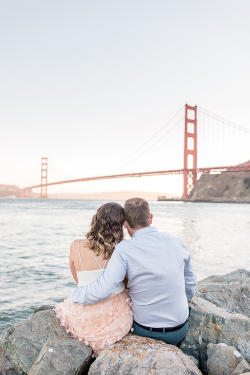 engaged couple looking at the Golden Gate Bridge