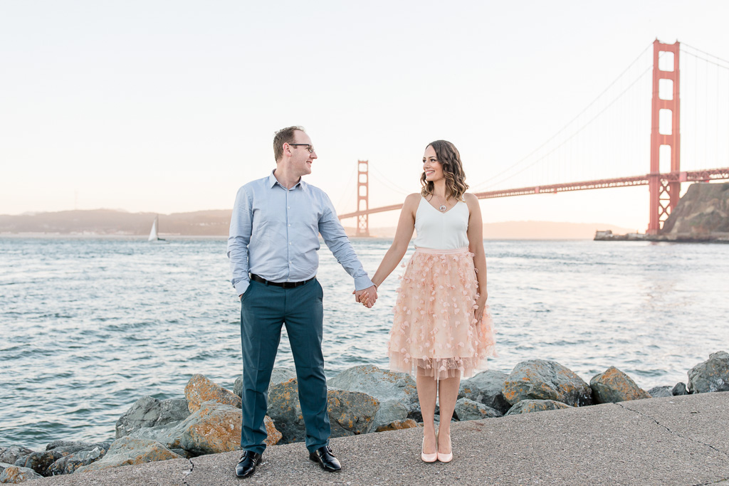 photo of couple holding hands in front of the Golden Gate Bridge