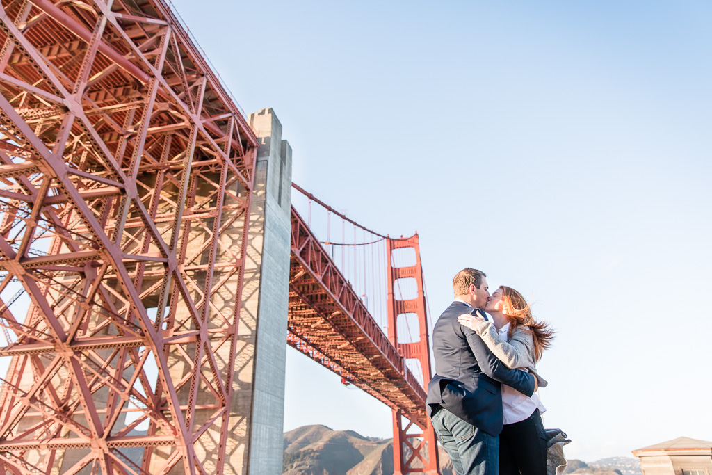 couple portrait taken at a different angle from below the golden gate bridge