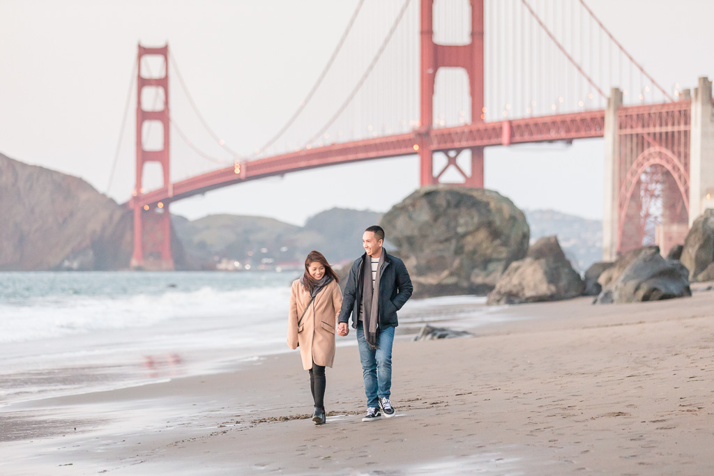newly engaged couple walking along San Francisco ocean beach