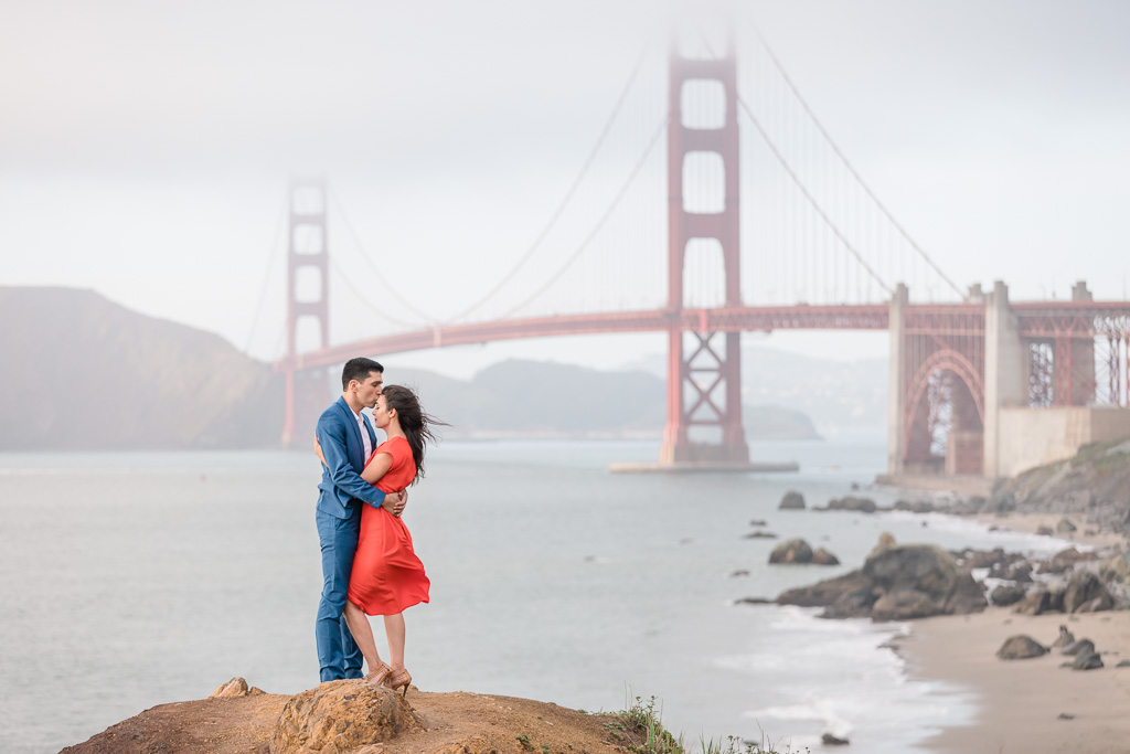 epic engagement photo in front of a cloudy Golden Gate Bridge