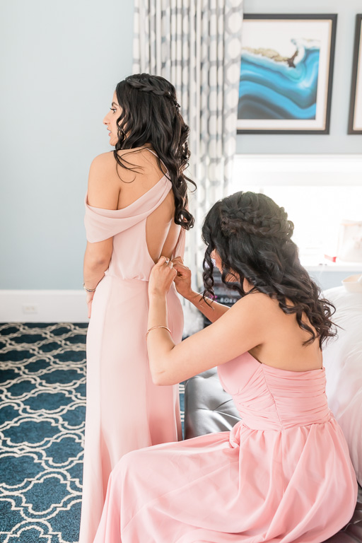 bridesmaids zipping up each other