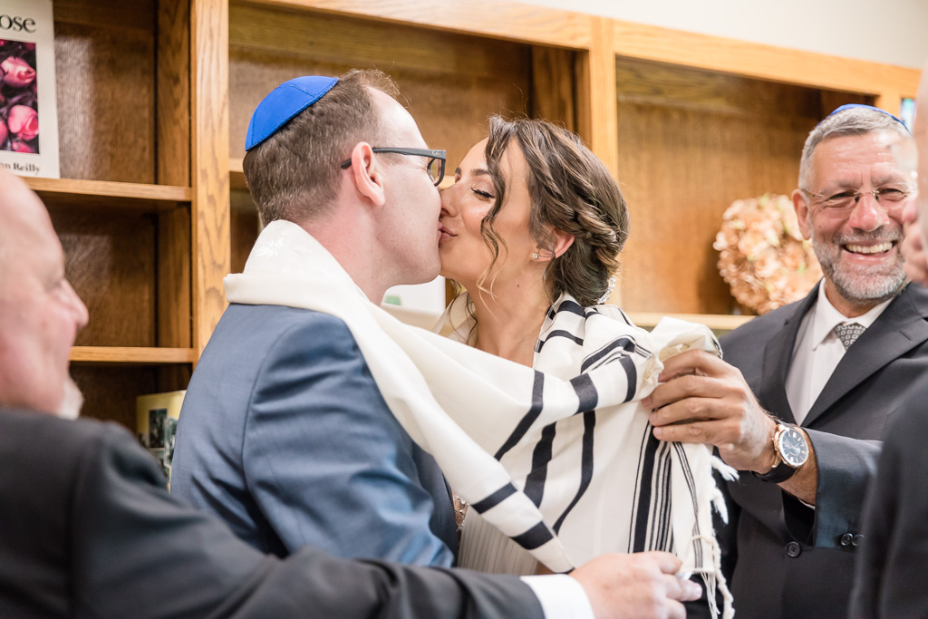 couple kissing at the end of the ketubah signing