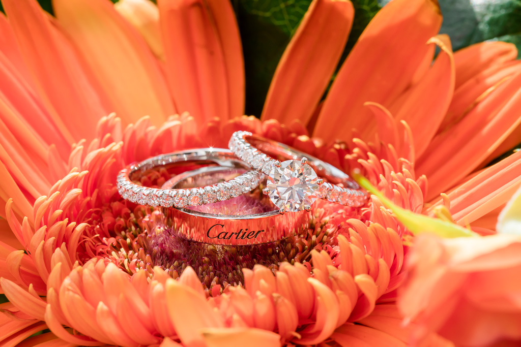 shiny reflective Cartier wedding and engagement rings inside a flower