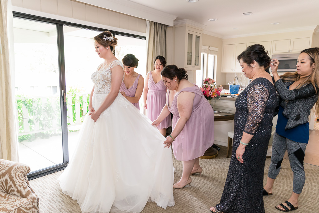 bridesmaids helping the bride with her dress