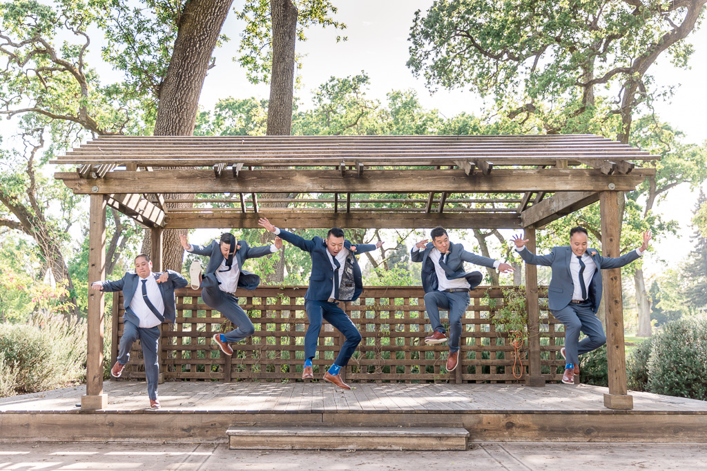 action shot of groom and groomsmen jumping off a step