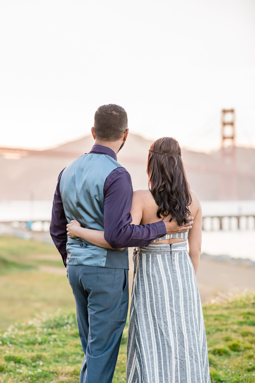 engagement photo of couple looking at the golden gate bridge