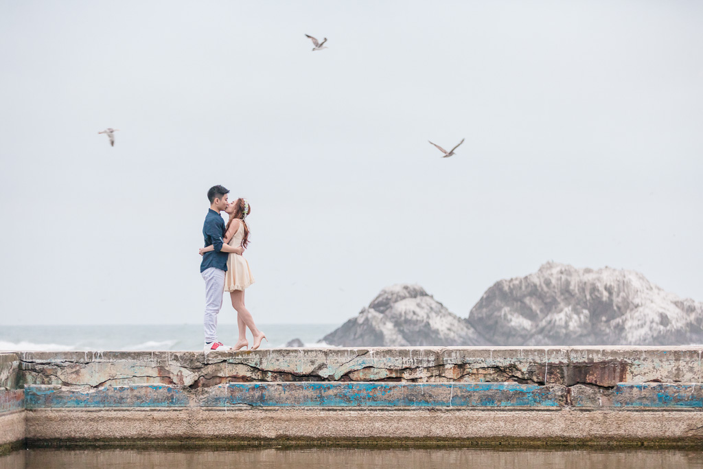whimsical Lands End engagement photo with flower crown and birds