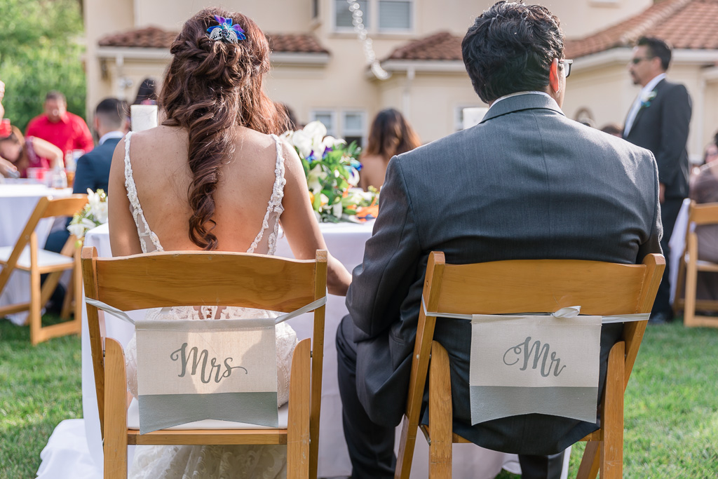 mr and mrs sign hanging on the chairs at the sweatheart table