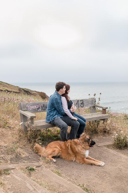 engagement photo on a bench overlooking the Pacific Ocean