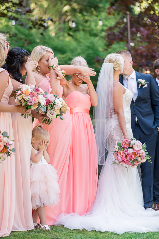 funny and cute Seattle wedding photo of the flower girl covering her eyes for the newlyweds' kissing
