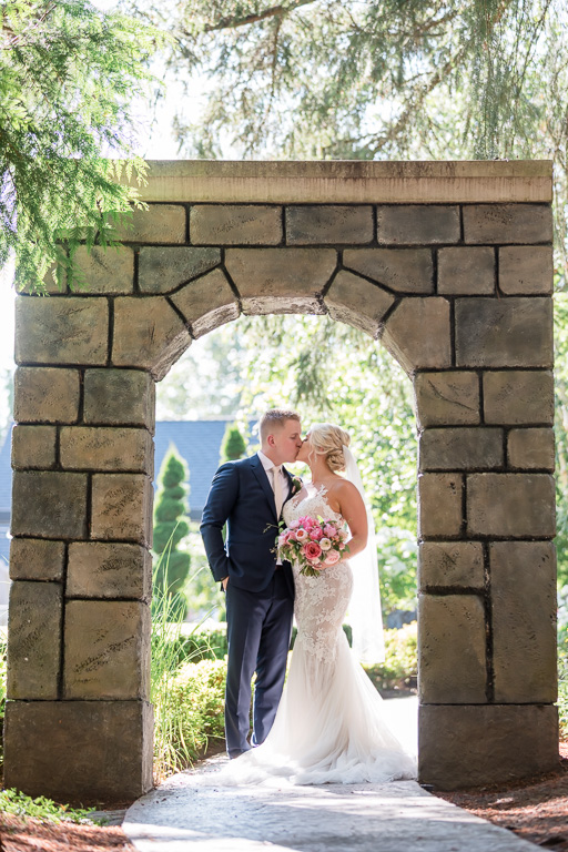 couple portrait under the stone arch at the Rock Creek Gardens
