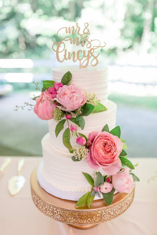 a plain wedding cake decorated with fresh flowers