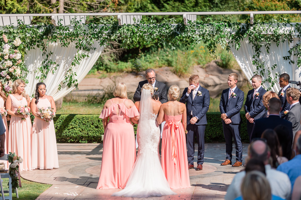 groom gets emotional when he sees his bride walking down the aisle at Rock Creek Gardens
