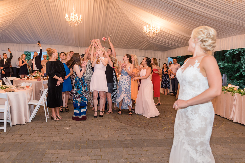 girls jumping up the air to catch the bouquet