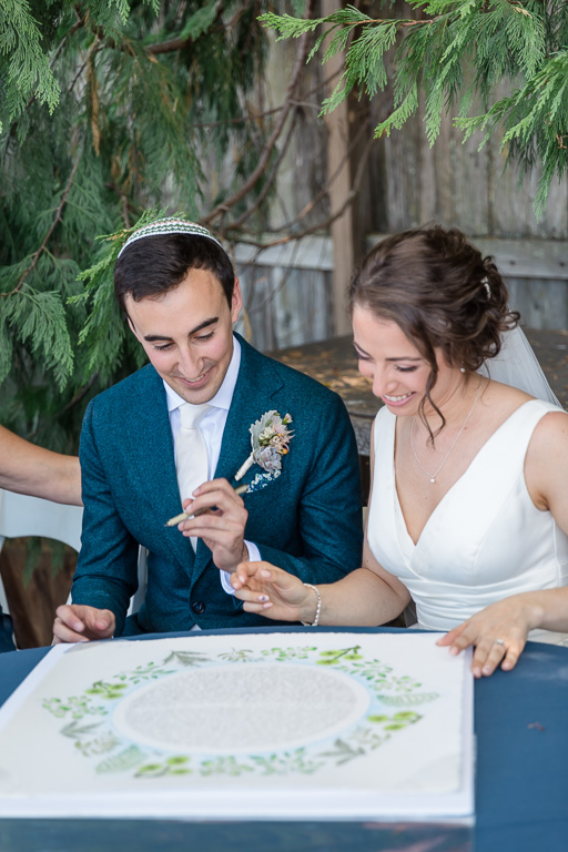 couples signing their beautifully designed ketubah
