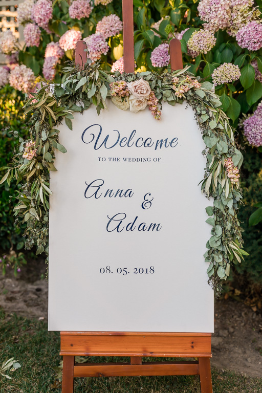 pretty wedding welcome sign in front of the flower wall