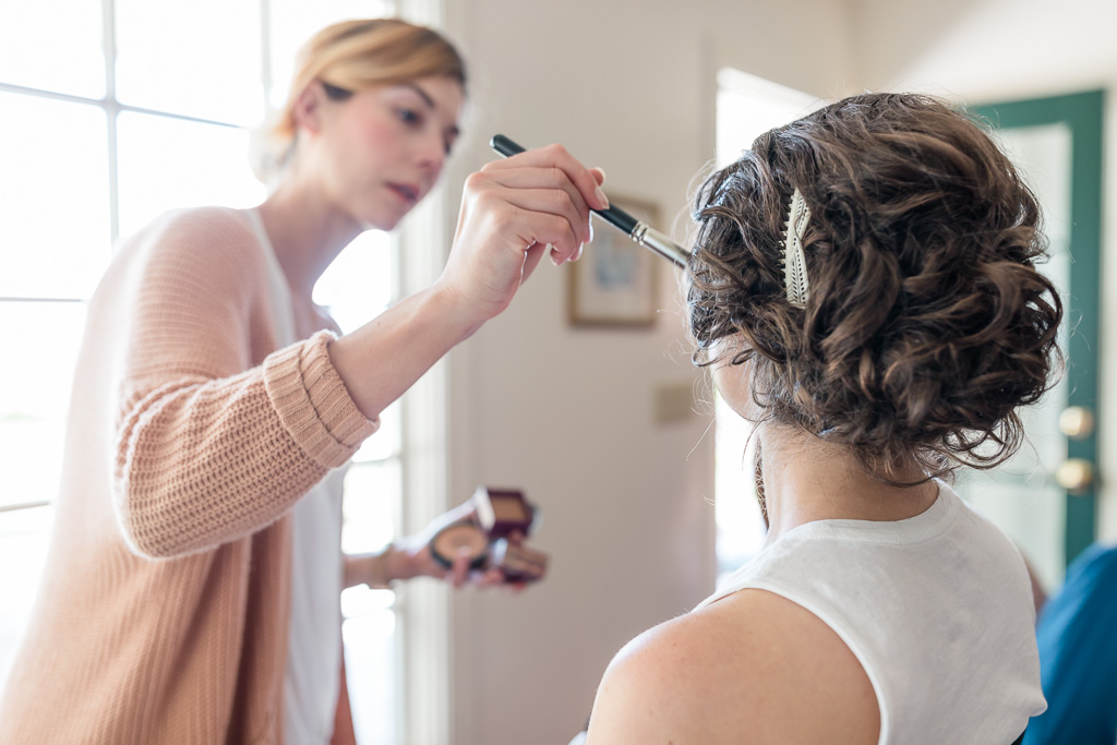 bride having her makeup and hair done in the house