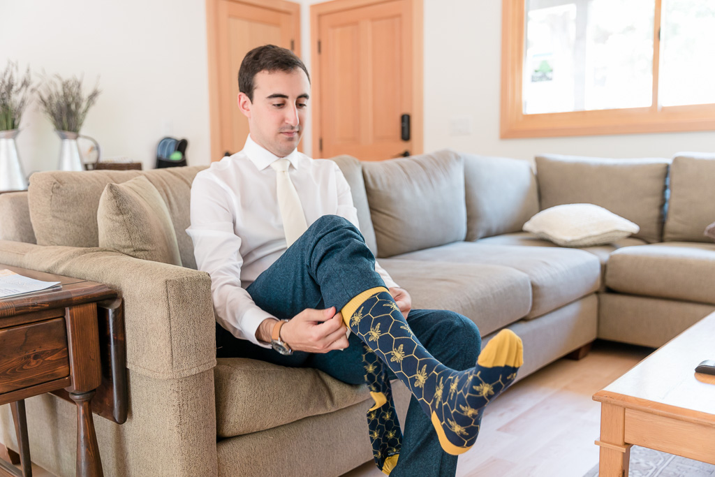 groom putting on his awesome bee socks
