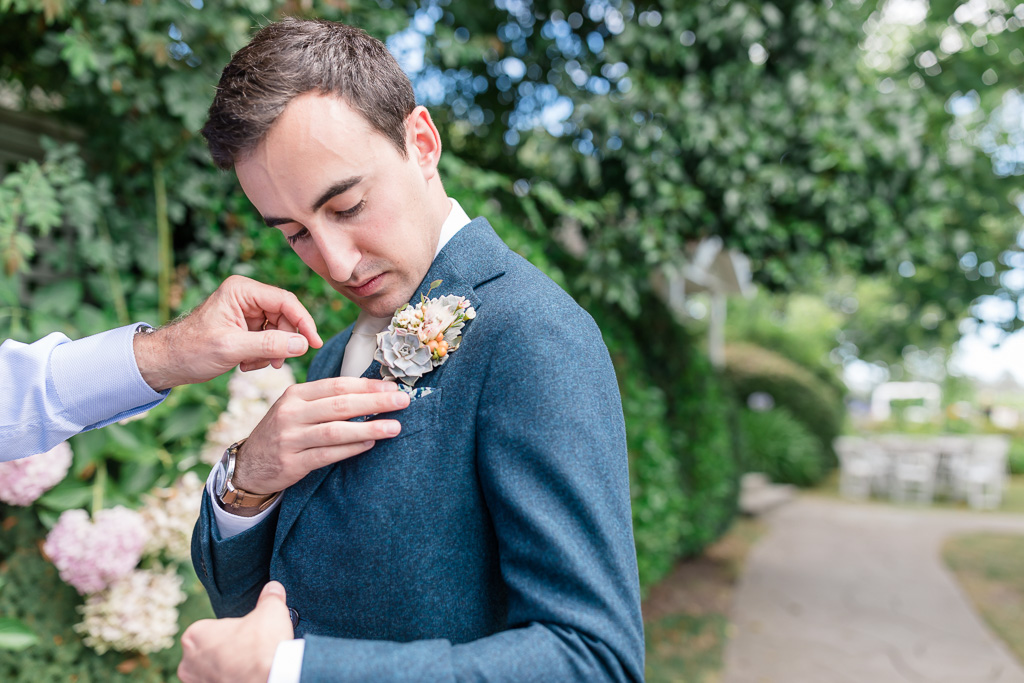 groom puts on the boutonniere