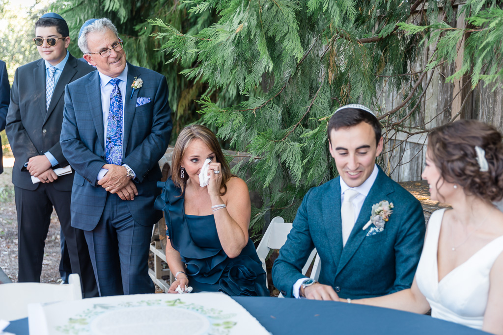 parents wiping happy tears at the ketubah signing