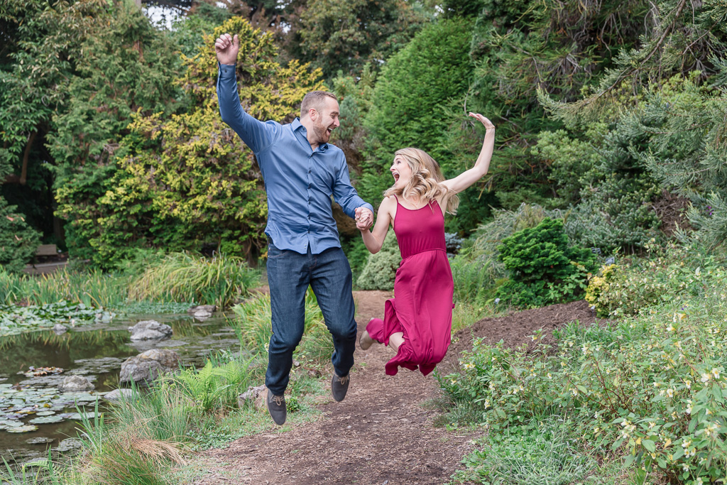 a cute jumping photo of the newly engaged couple