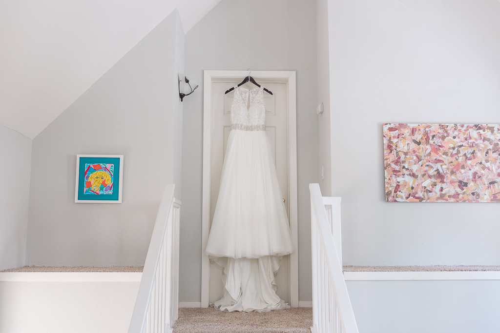 lace A-line wedding gown hanging on the door