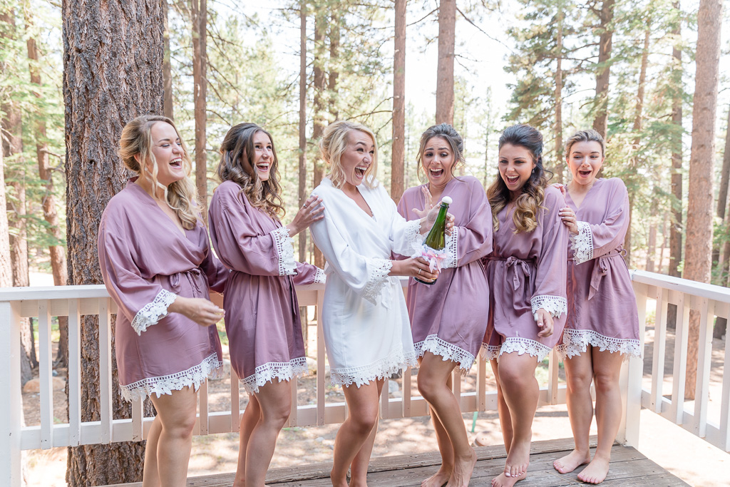 bride popping champagne with her bridesmaids in a Lake Tahoe airbnb