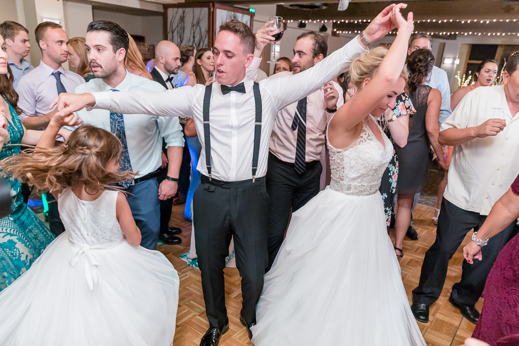 bride and groom dancing together with guests