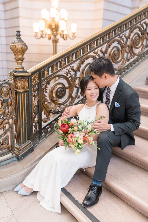 wedding photo sitting on the San Francisco City Hall grand staircase