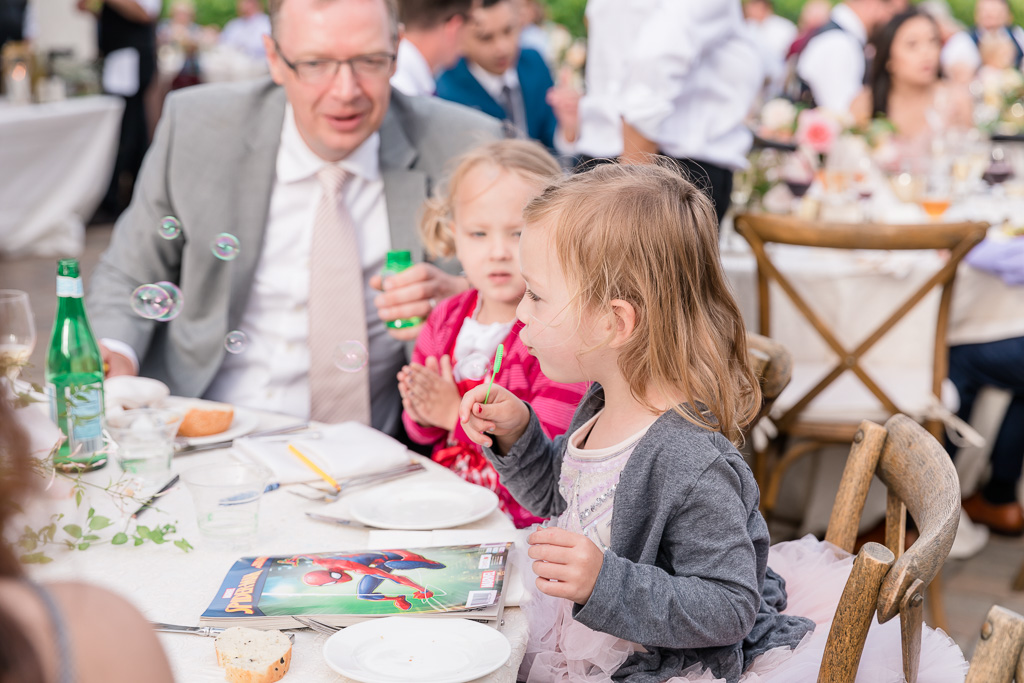 little wedding guests having fun blowing bubbles