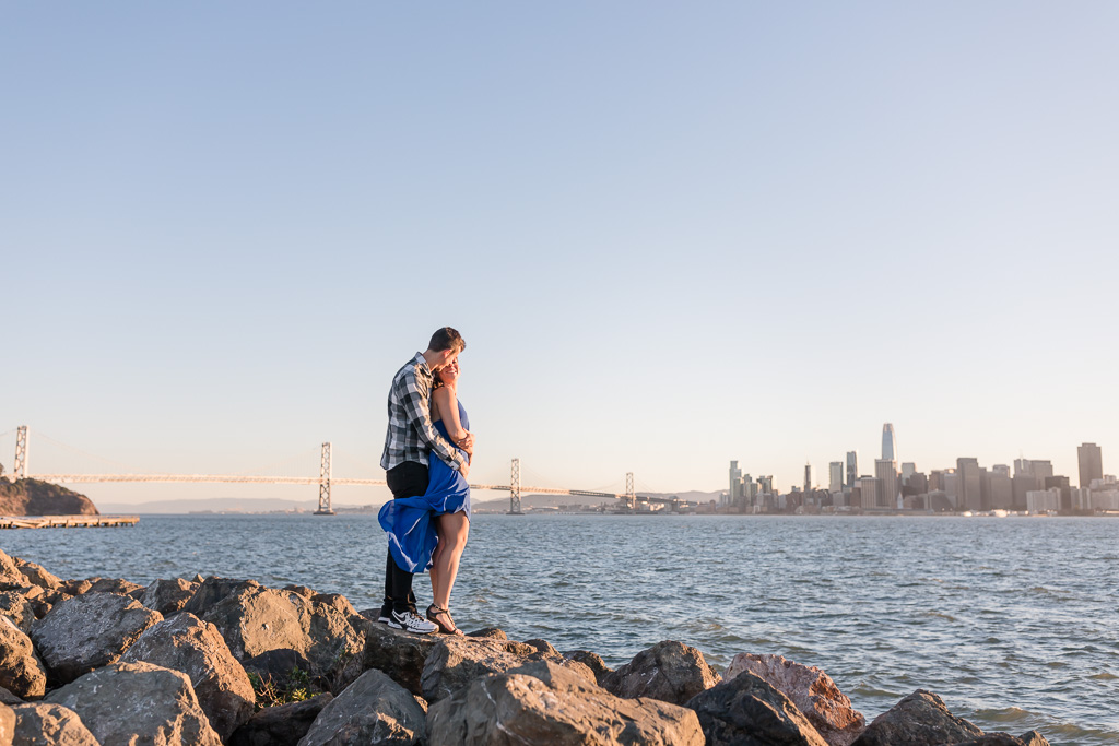 enjoying the San Francisco skyline view and the bridge during their engagement session