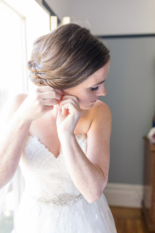 putting on the bridal earrings