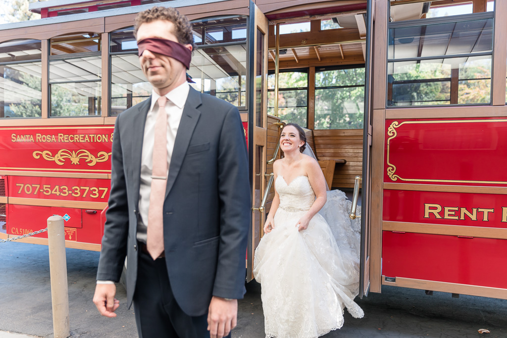 bride walks out of a trolley to surprise her groom