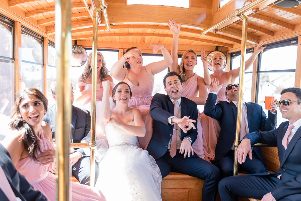 couple and wedding party having fun singing along to the rap songs on the trolley