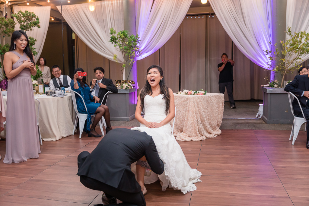 bride has a surprise for the groom during the wedding garter fetch