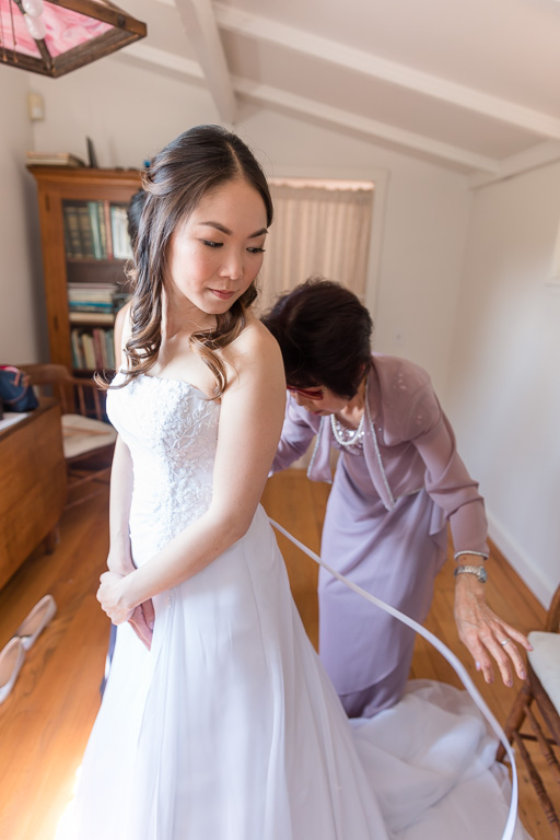 mother of bride helping put on dress
