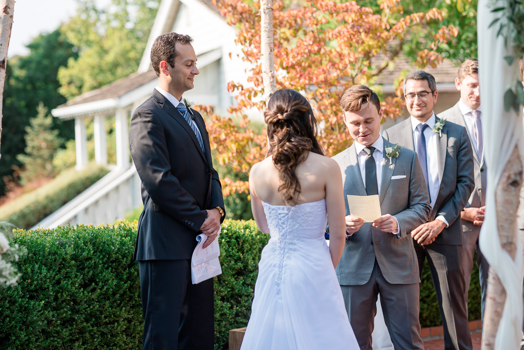 groom reading his handwritten vows during ceremony