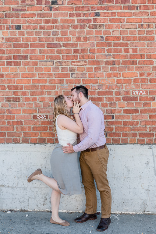 kissing by a brick wall