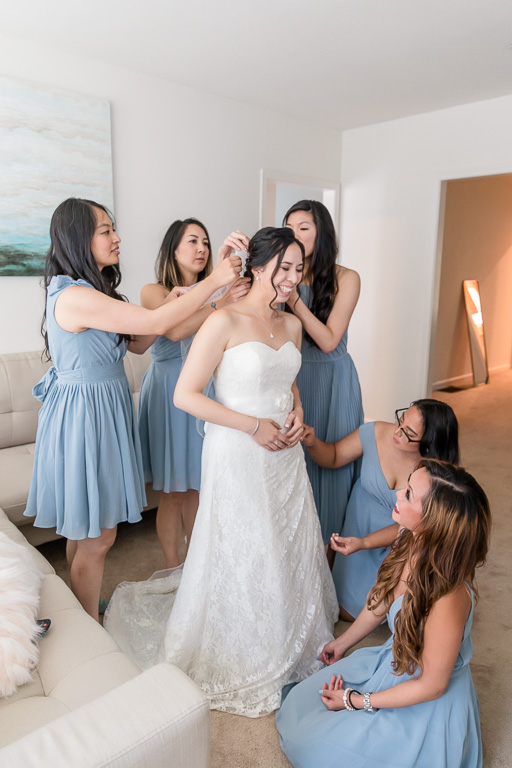 bridesmaids helping bride with her hair pieces