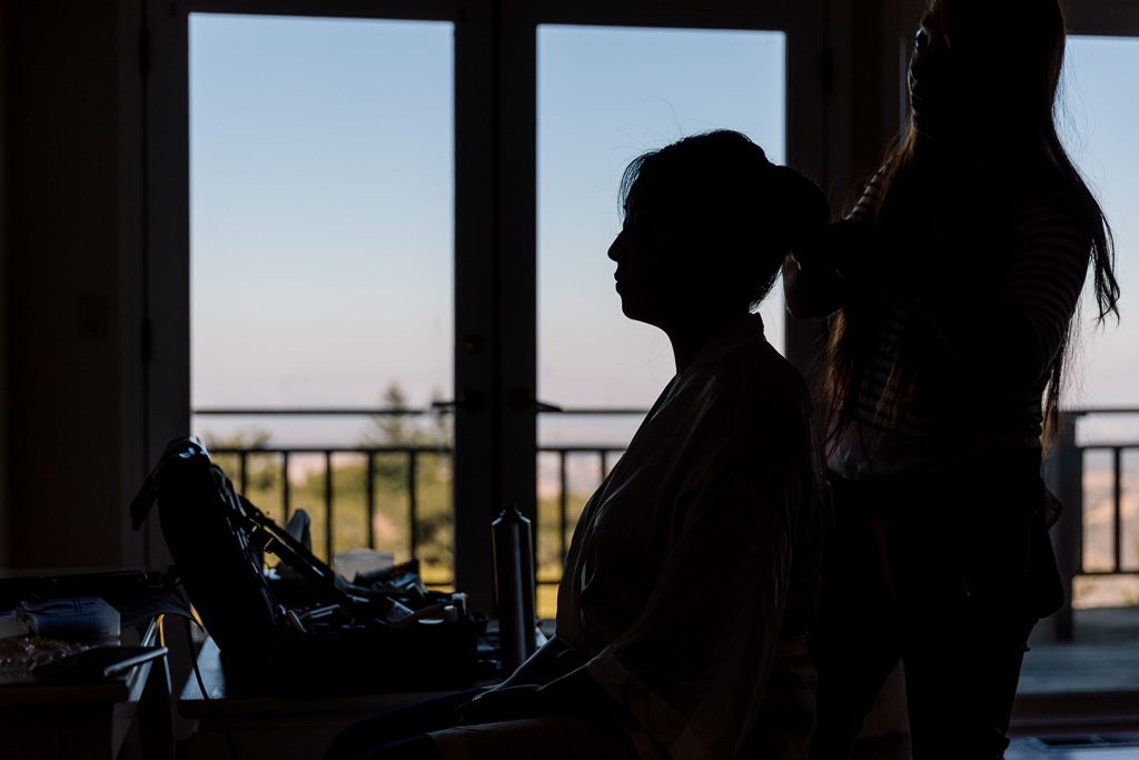 silhouette shot of the bride having her makeup done
