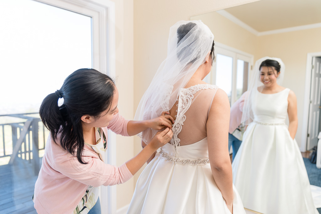 officiant helping the bride to button up her dress