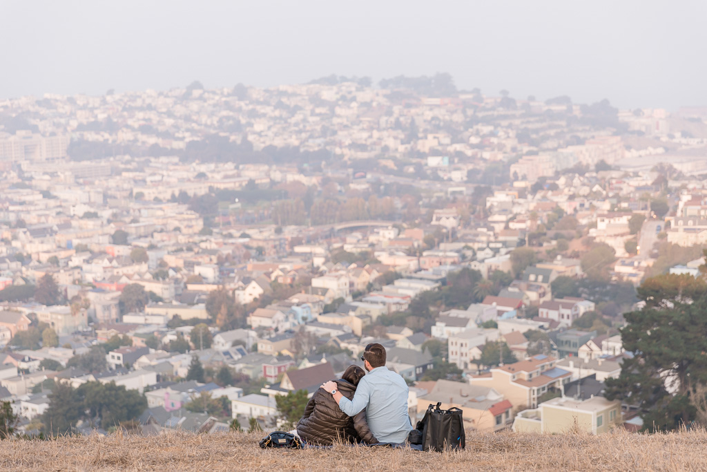 couple sitting on the hill enjoying the view of San Francisco