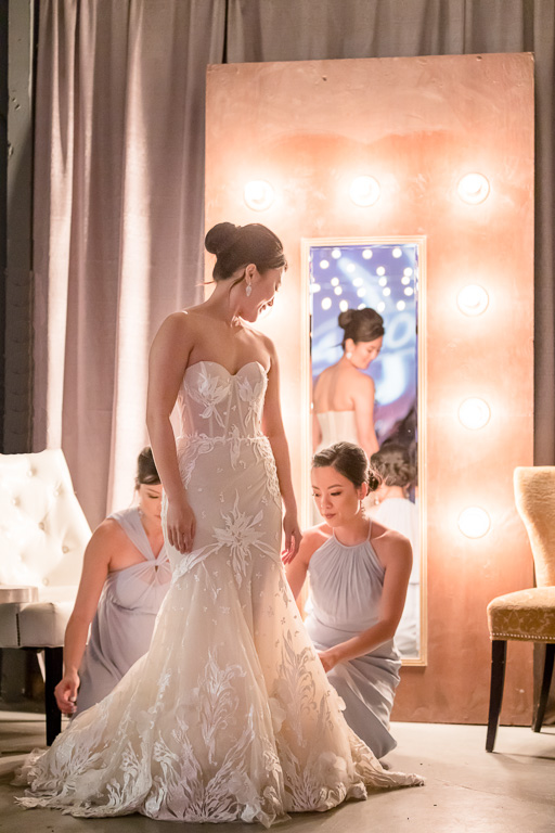 bridesmaids helping bride looking stunning in front of a mirror at the Winery SF