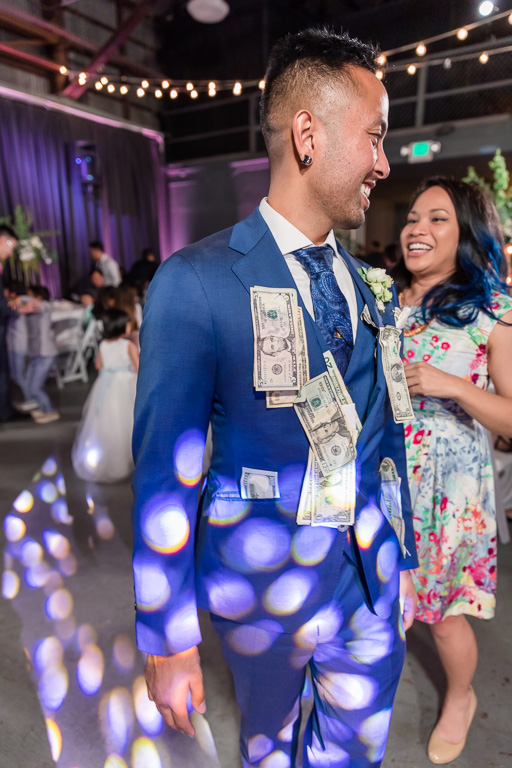 groom with lots of cash pinned during money dance