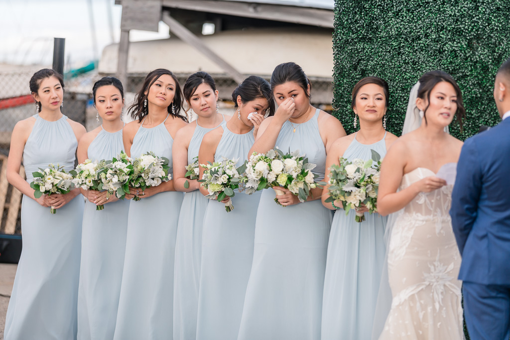 bridesmaids wiping tears during touching wedding ceremony