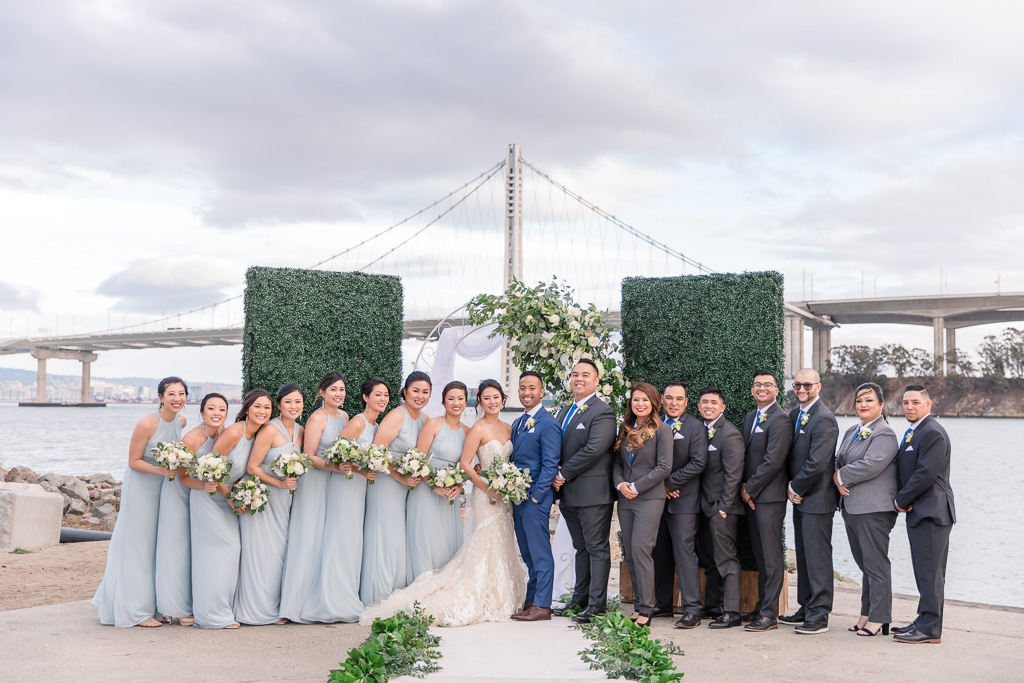 bridal party photo lined up in front of the Oakland Bay Bridge