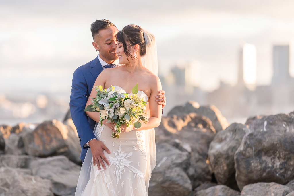 golden hour photo of bride and groom in front of San Francisco city skyline