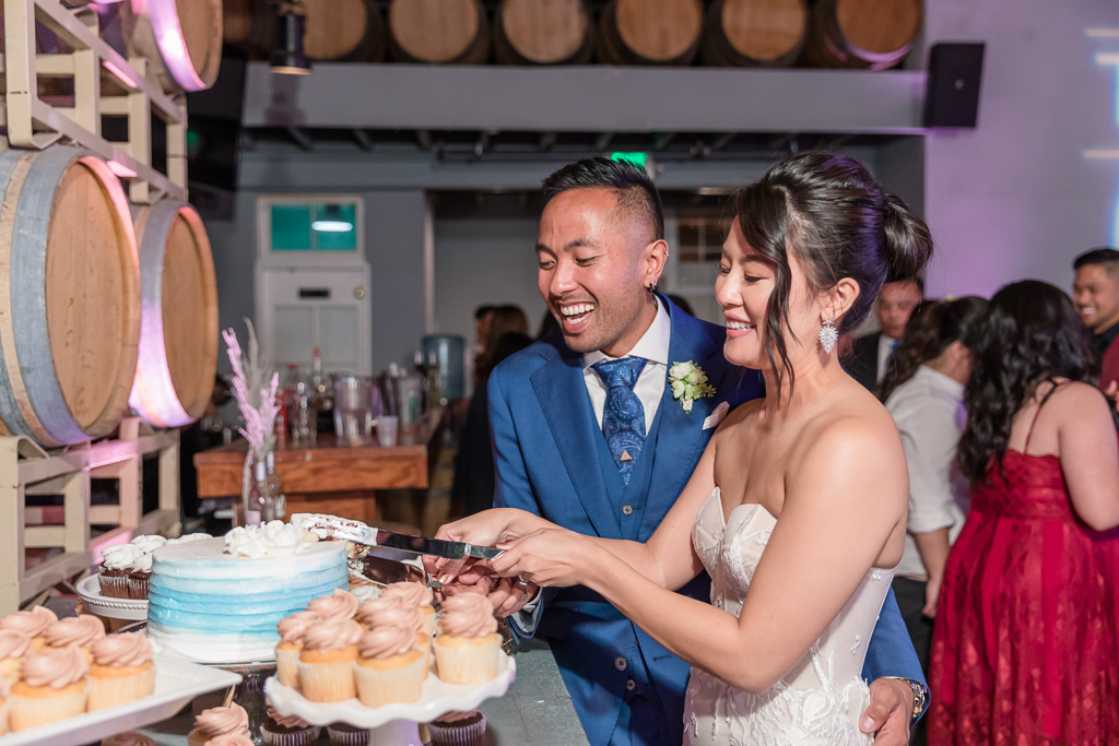 bride and groom cheerfully cutting wedding cake