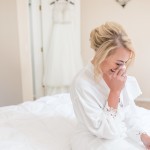 emotional moment of bride wiping away a tear on the morning of her wedding
